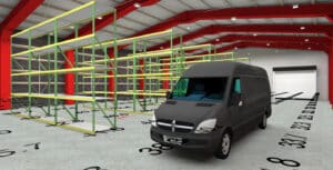 A gray delivery van is parked inside a warehouse with empty yellow-green metal storage racks and red ceiling beams. Number markings are visible on the floor.